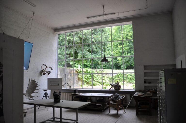 Das Atelier von Fritz Koenig auf dem Ganslberg - Aufnahme von Innen. Eine Glaswand lässt viel Licht hinein und ermöglicht einen Blick ins Grüne.