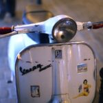 Altes Moped in weißer Farbe mit Aufklebern auf der Front