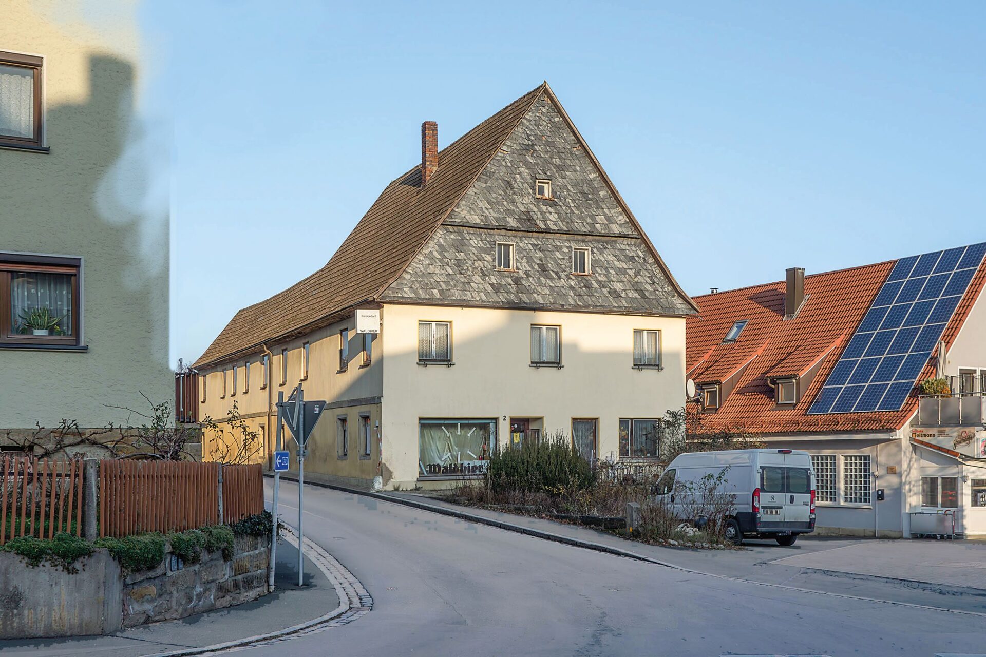 Das Gasthaus in Thurnau. Es liegt direkt einer Straße, Blick auf die Giebelseite, die obere Hälfte ist mit Holz verkleidet
